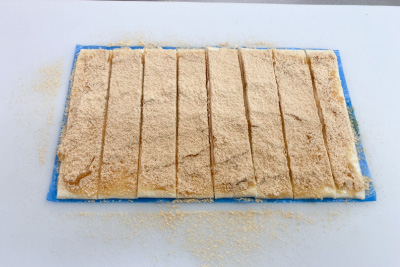 パイ生地にピーナッツバターを塗り、きな粉をかけて切る